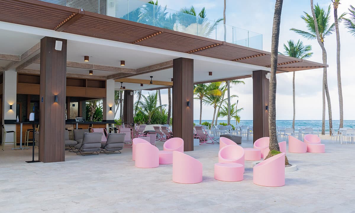 Loungeterras met roze stoelen en uitzicht op zee