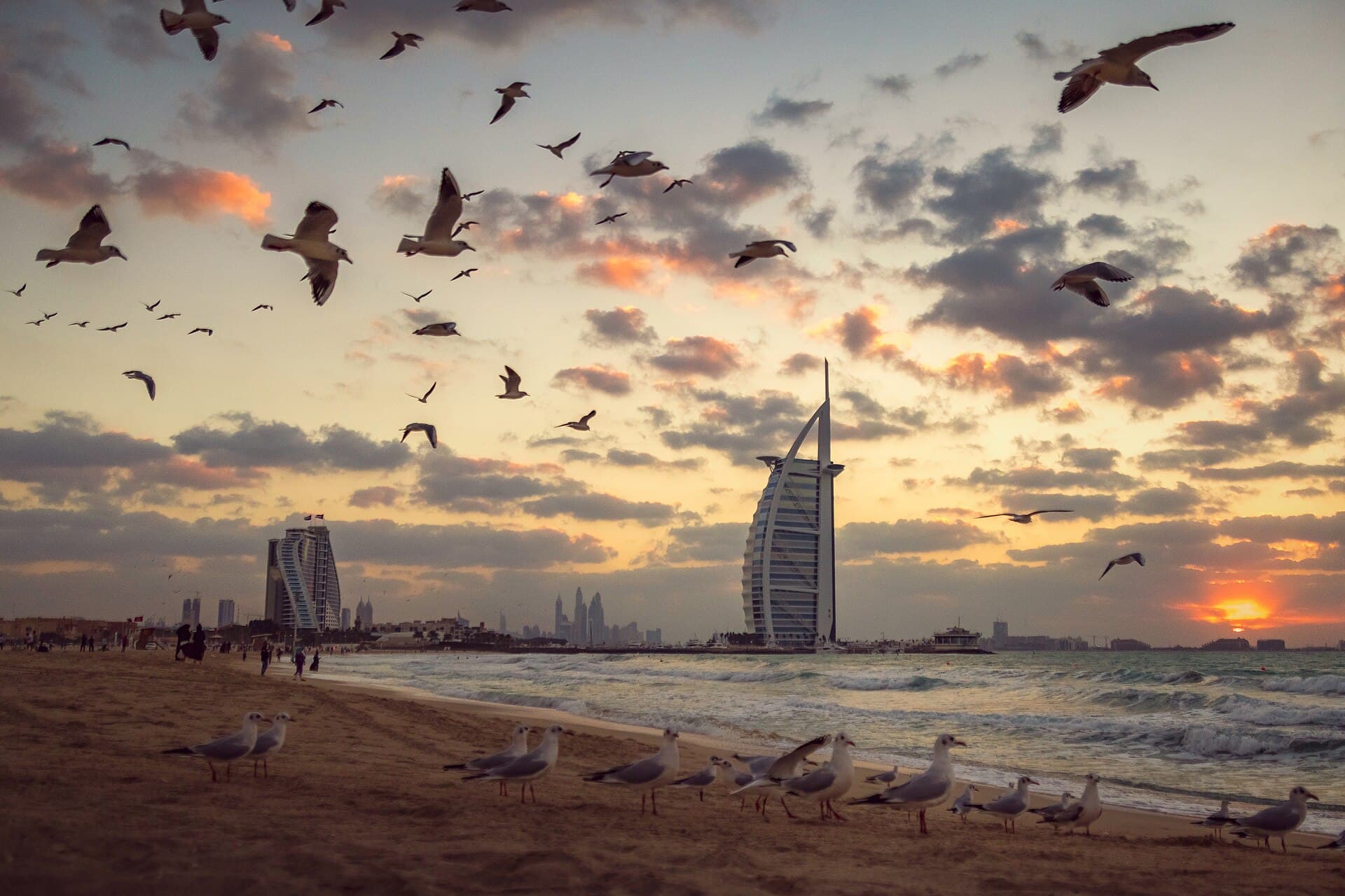 Zonsondergang bij de Burj Al Arab met meeuwen op het strand
