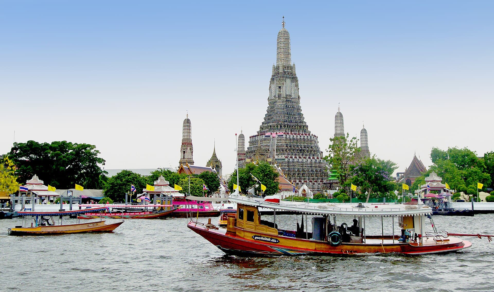 Wat Arun aan de Chao Phraya in Bangkok, met boten op de rivier